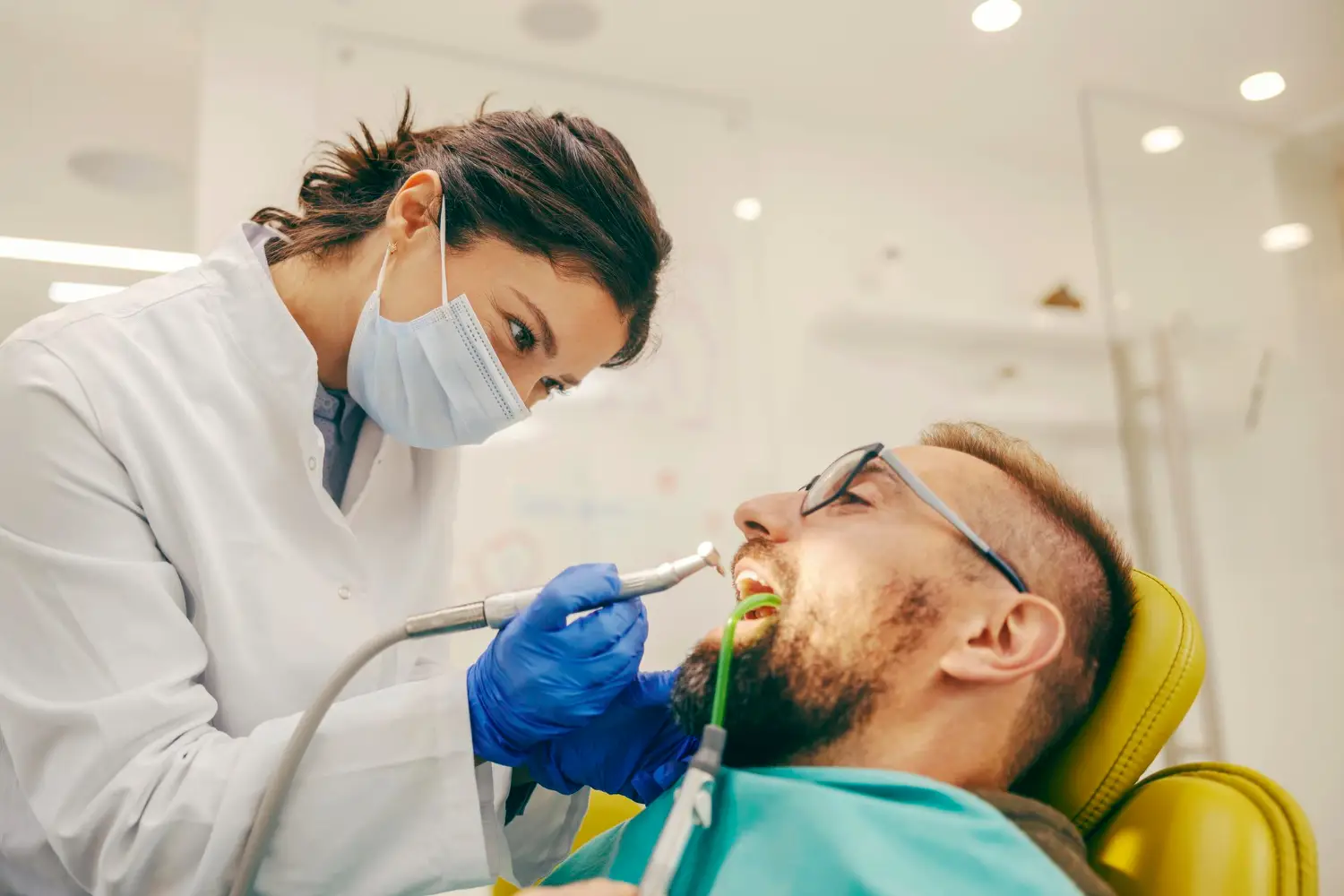 Dentist providing routine dental treatment to a patient in a modern dental office.