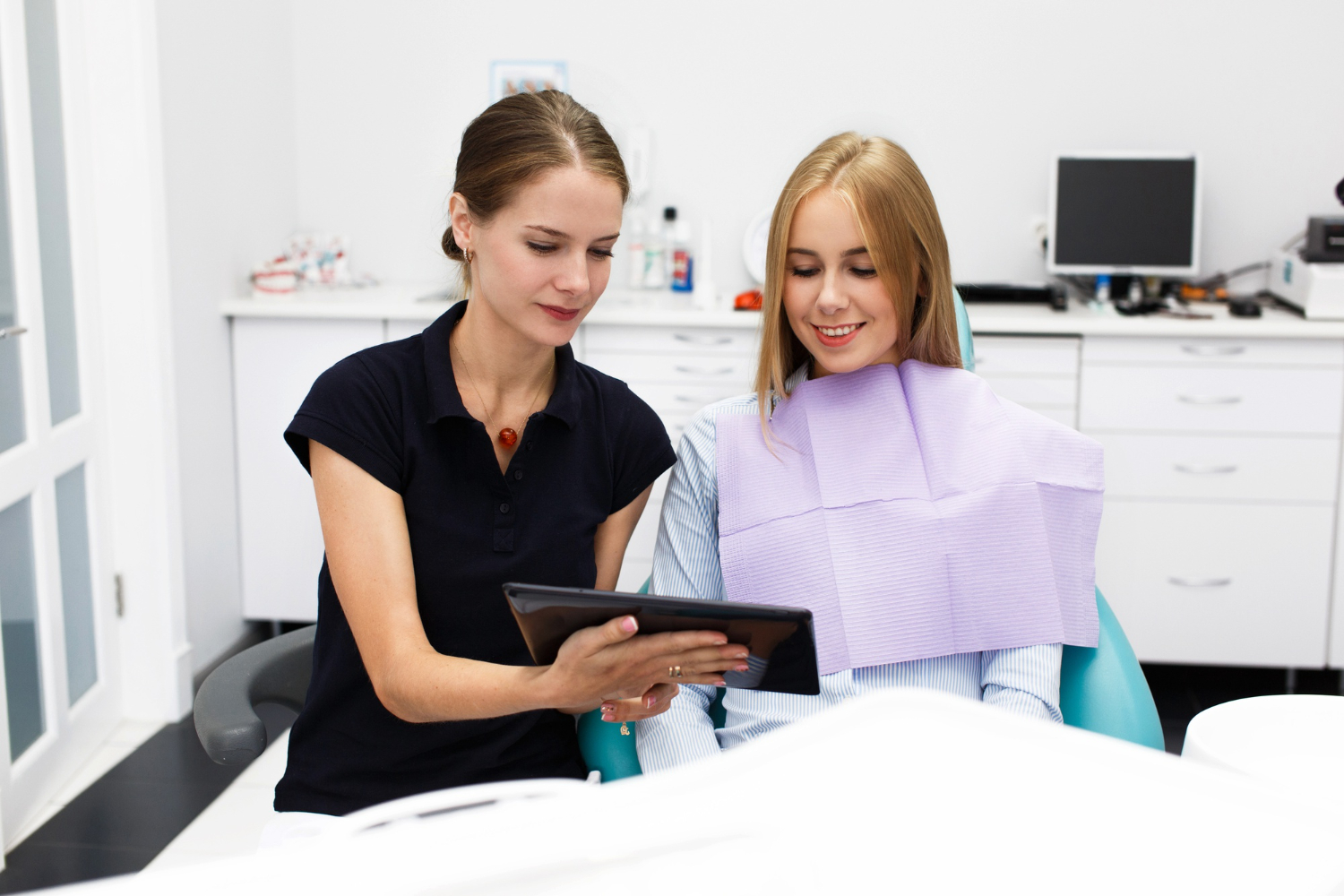 Dentist discussing smile makeover treatment options with a patient during a dental consultation.