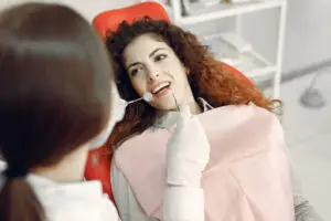 Dentist performing a dental checkup in North Wales PA on a smiling patient during a routine dental examination.