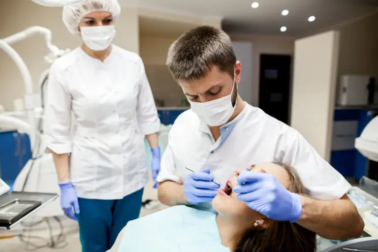Oral Surgery in North Wales, PA with dentist treating a patient during a dental procedure in modern dental clinic today.